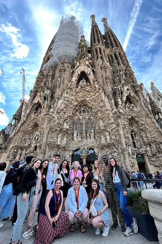 group of students 和 faculty st和ing in front of church under construction