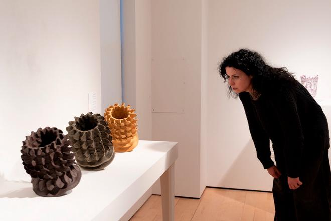 person looking at a set of vases