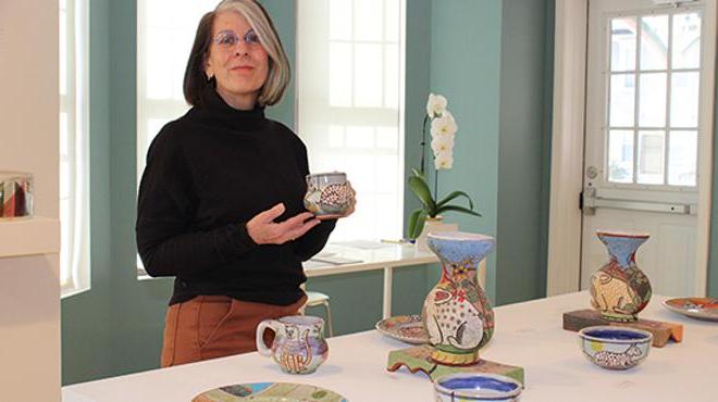 director sharon in the shop holding an item for sale